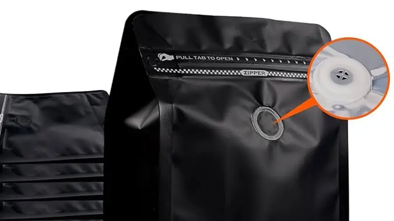 Black coffee bag with a close-up of its degassing valve